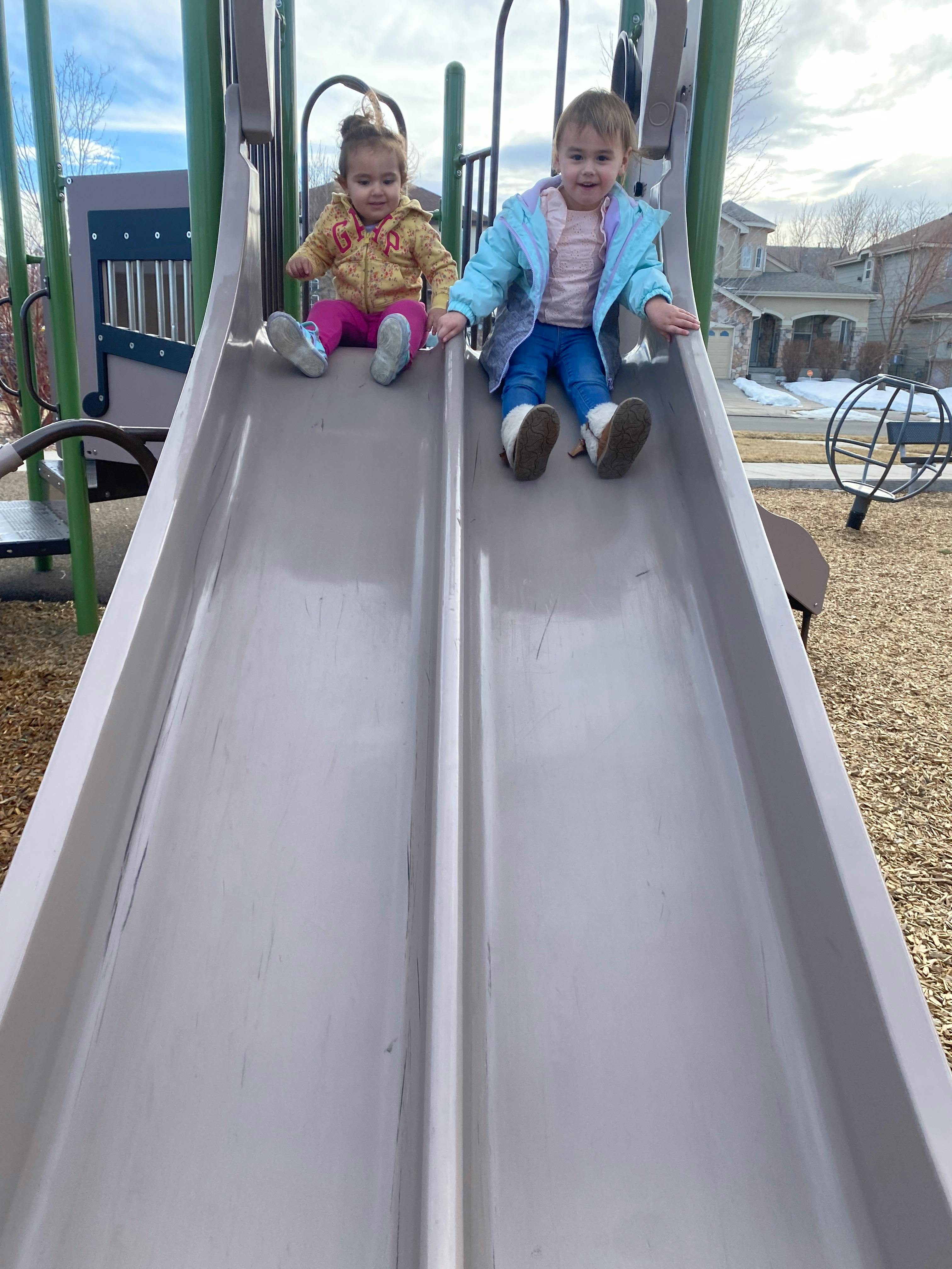 Two children sitting on a playground slide