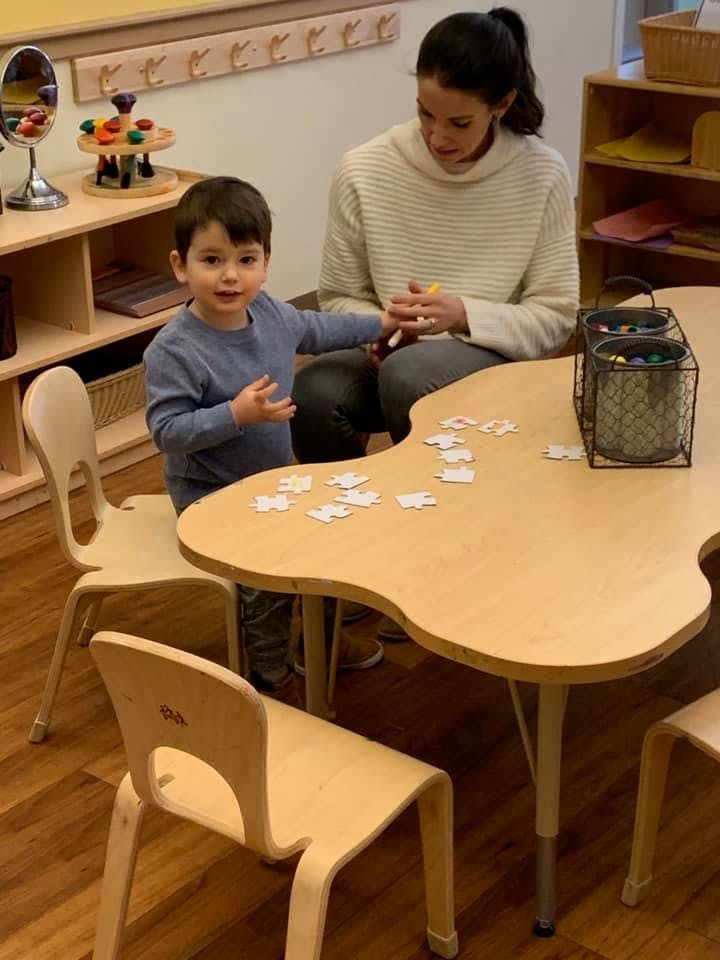 Adult and child at a table with puzzle pieces