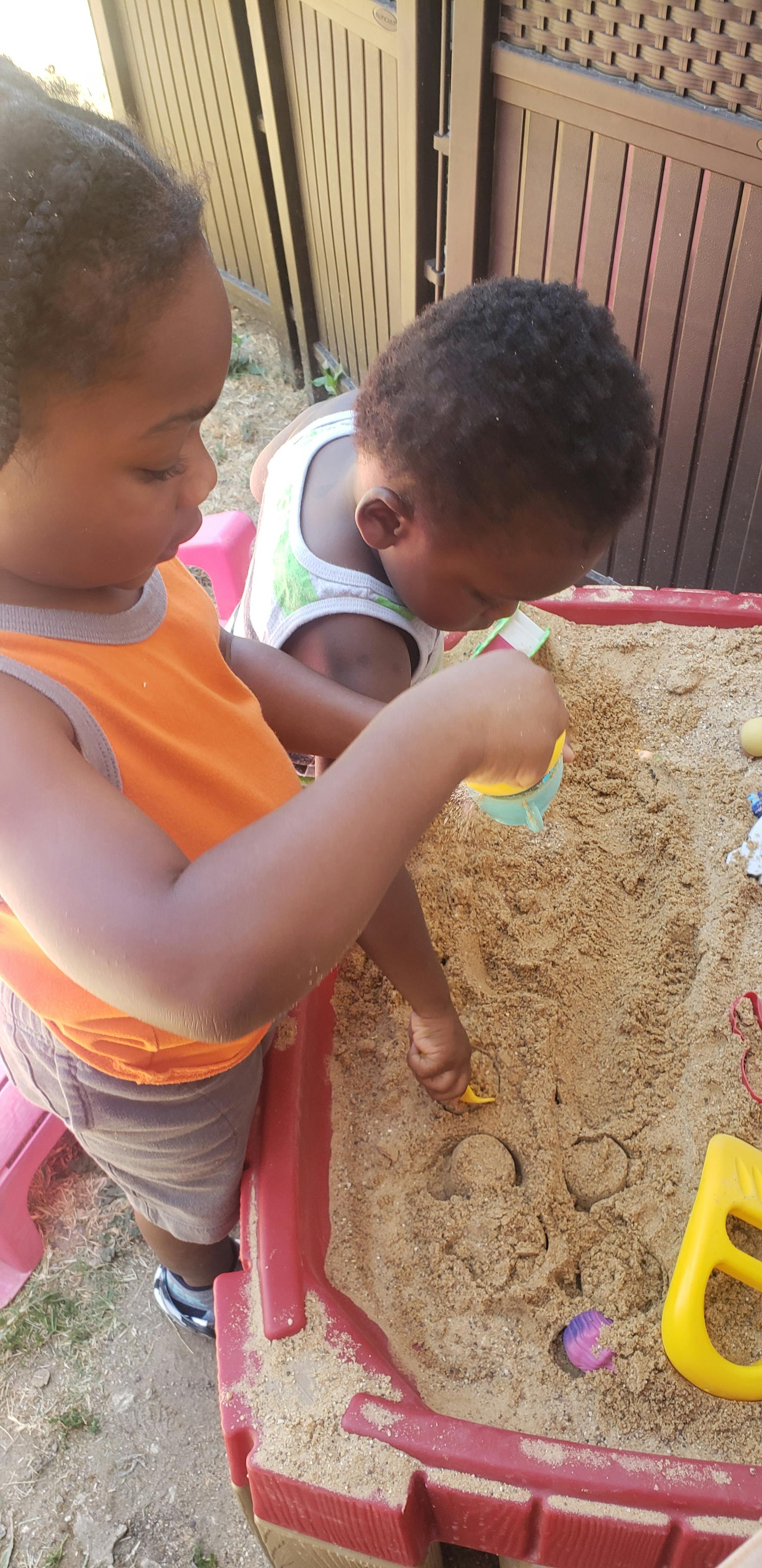 Two children playing in a sandbox
