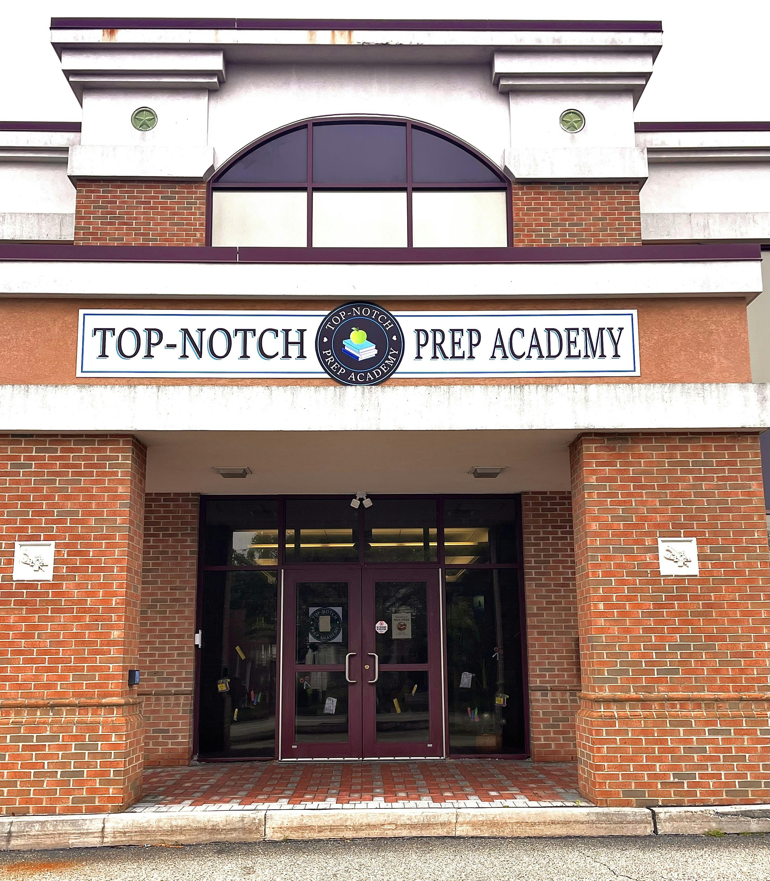 Building entrance with a sign that reads "TOP-NOTCH PREP ACADEMY"