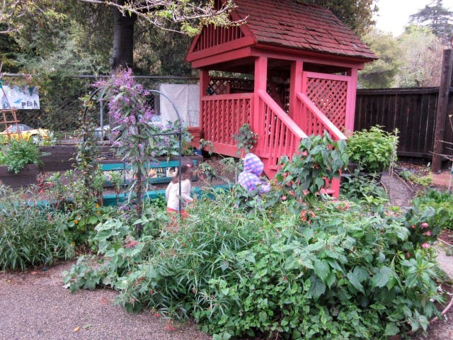 Red wooden playhouse in a garden