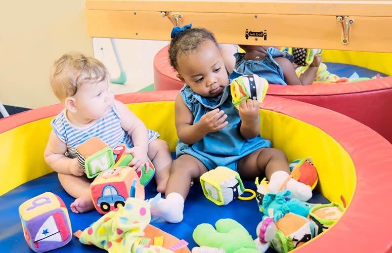 Two children playing with toys in a soft play area
