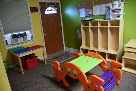 Classroom with small tables, chairs, and cubbies