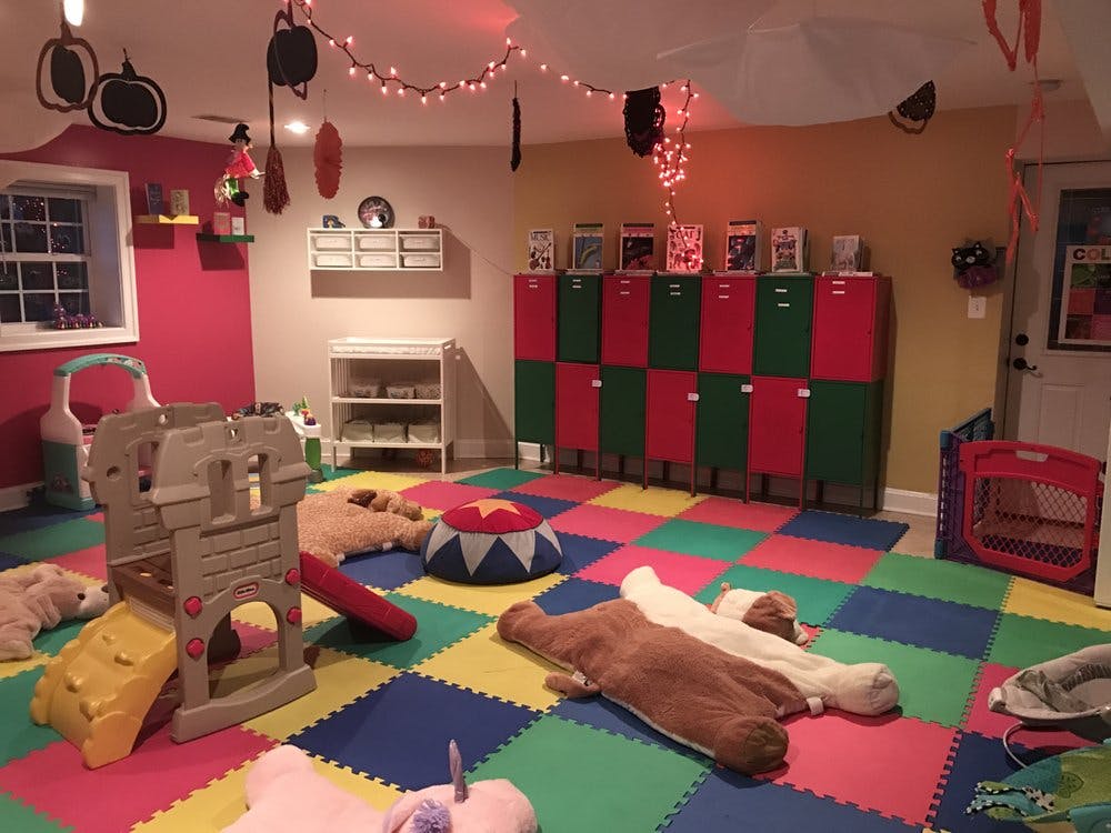 Playroom with colorful floor mats, red and green lockers, and play structures