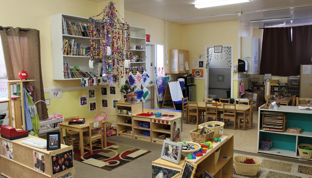 Classroom with small tables and chairs, shelves, and decorations