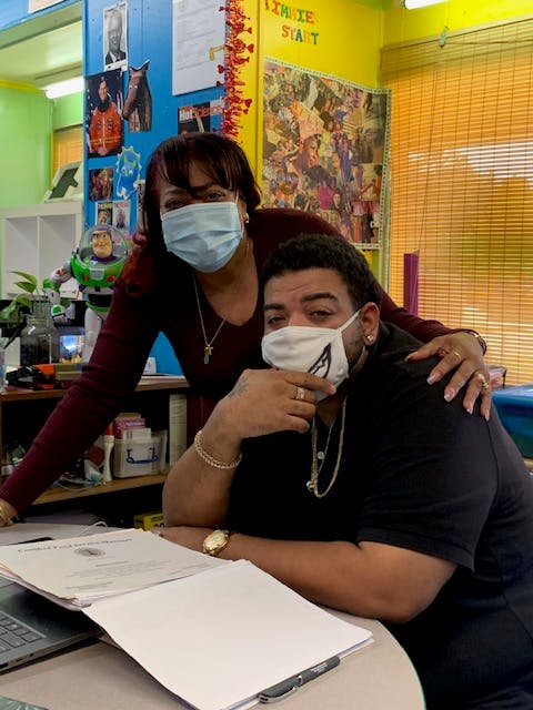 Two people wearing face masks in a classroom