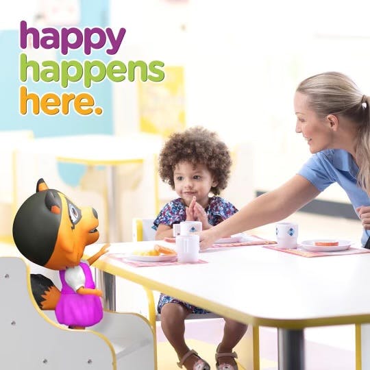Adult and child at a table with a cartoon character
