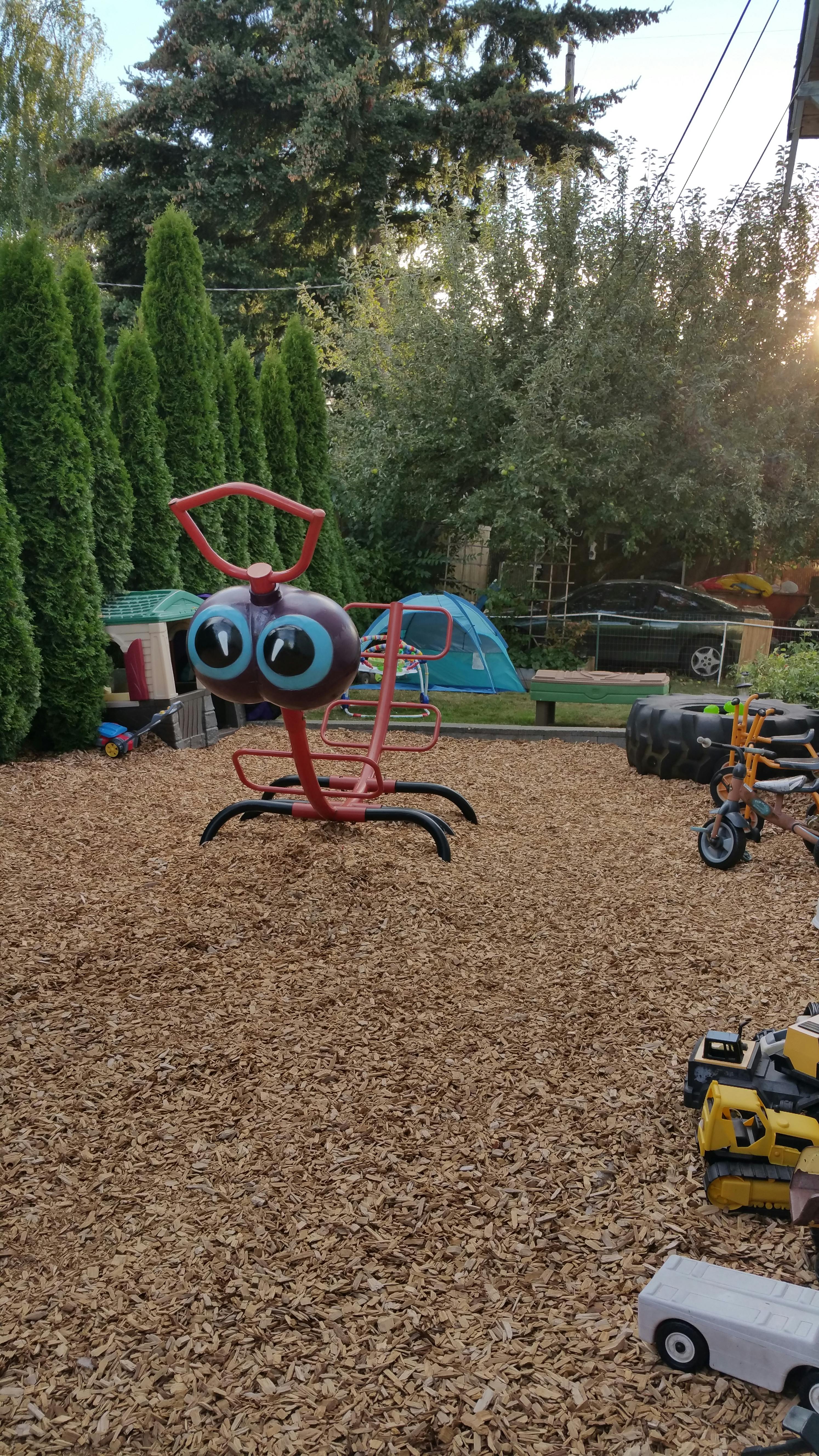 Red and purple spring rider on wood chips in a playground