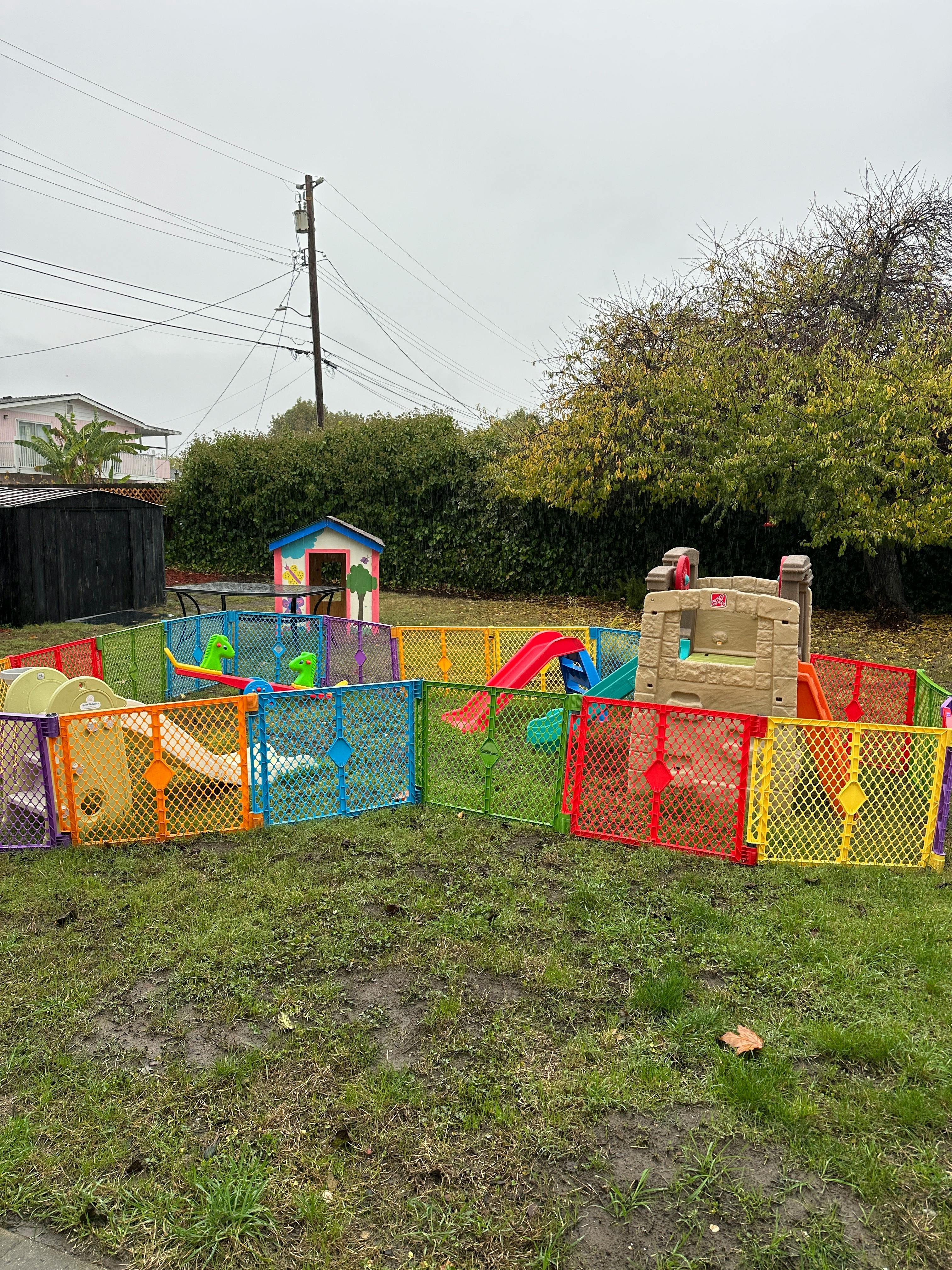 Outdoor play area with colorful fences, slides, and playhouses