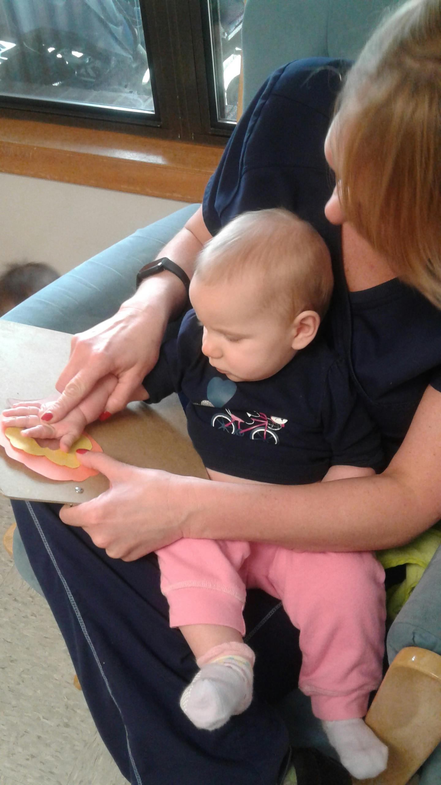 Person holding a child who is touching colorful fabric swatches