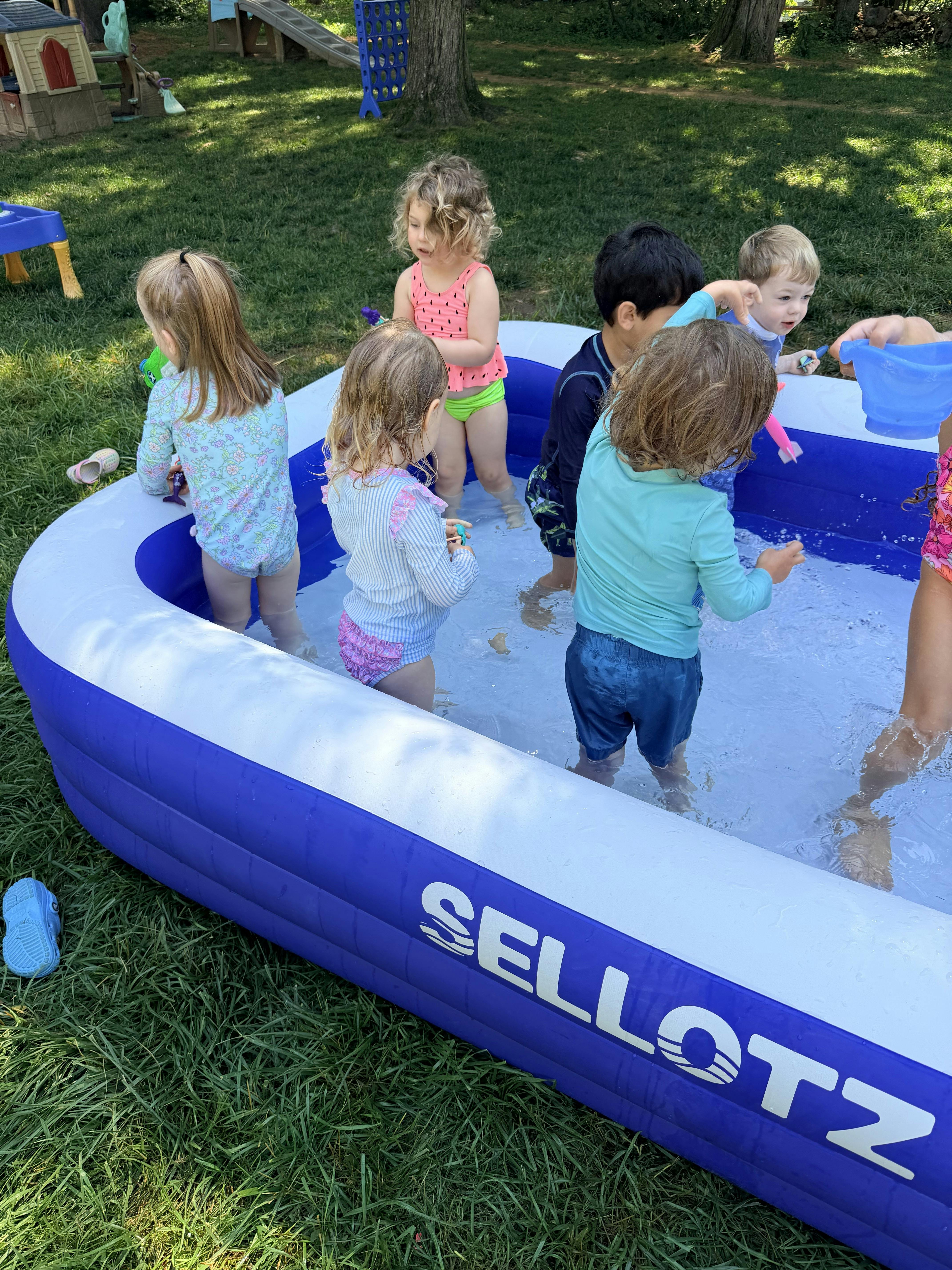 Group of children playing in a backyard inflatable pool