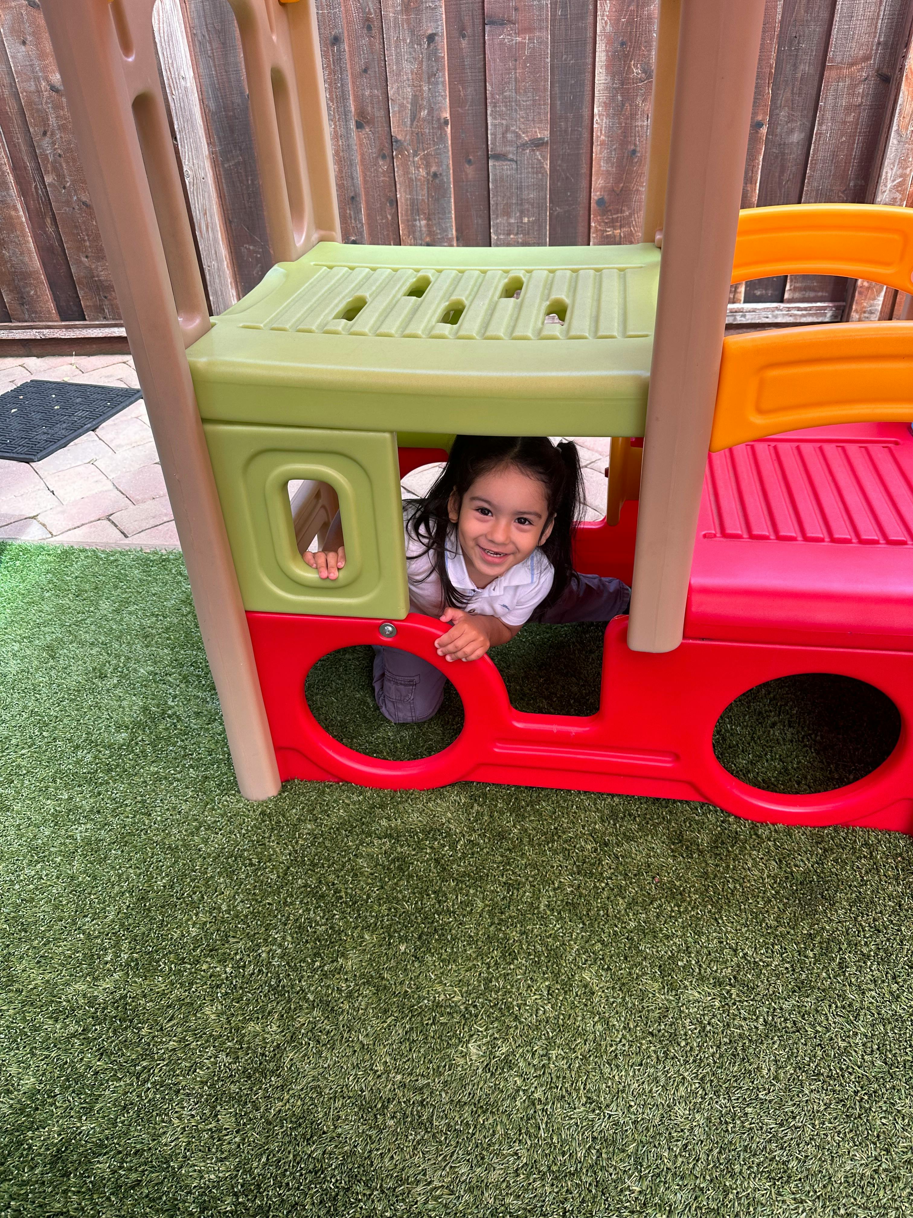 Child looking out from inside a play structure