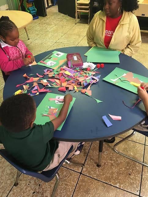 Adult and two children doing crafts at a table