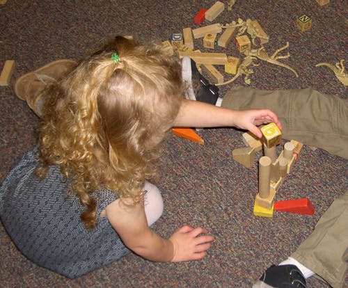 Child playing with wooden blocks on the floor