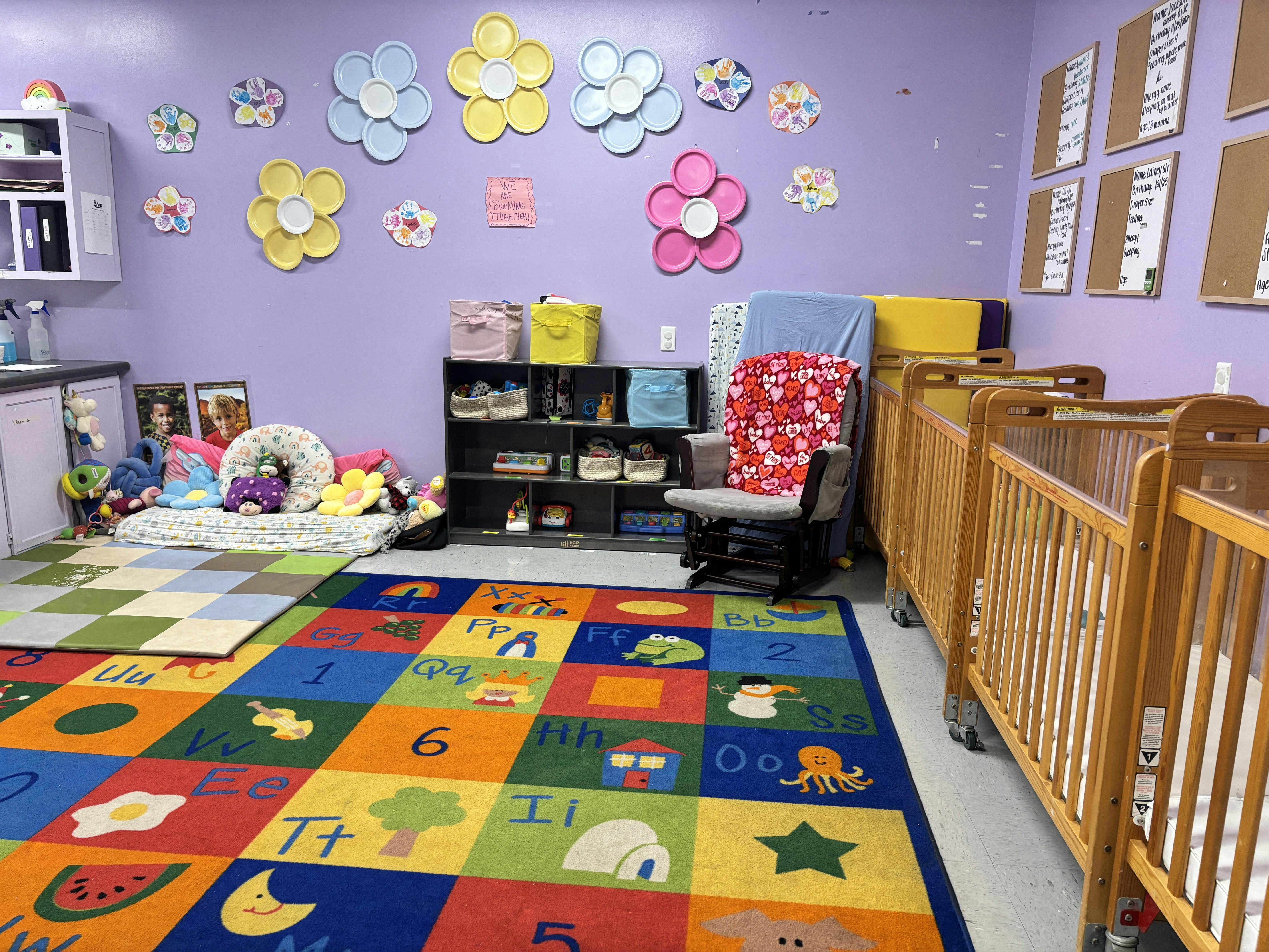 Colorful daycare room with infant cribs and floor play mats