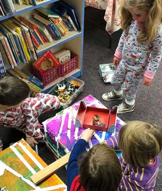 Children playing with toys and books in a classroom