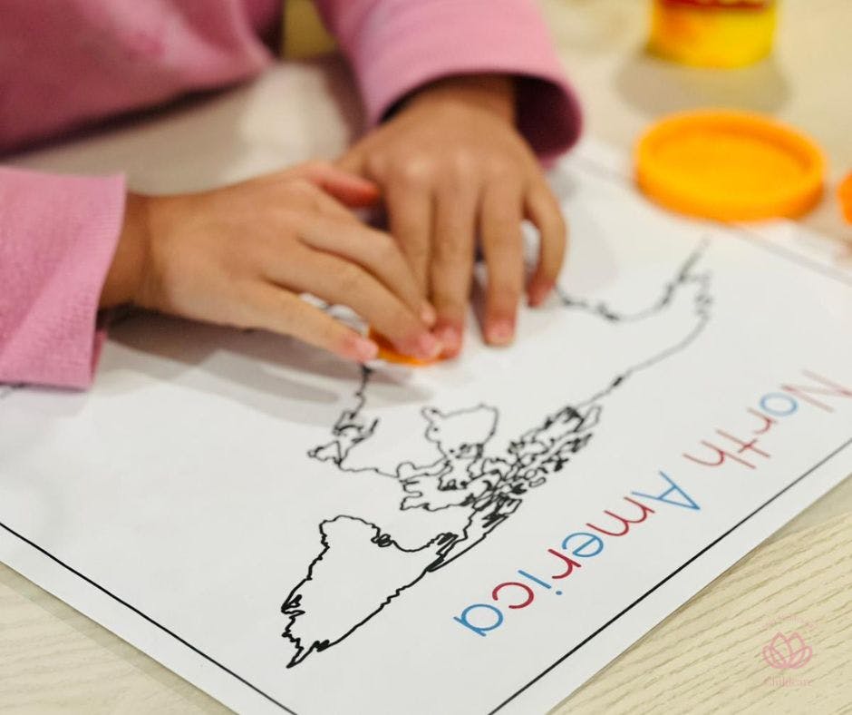 Child's hands working on a map of North America