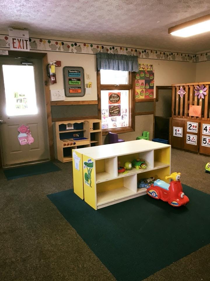 Playroom with toys, shelves, and a small red ride-on scooter