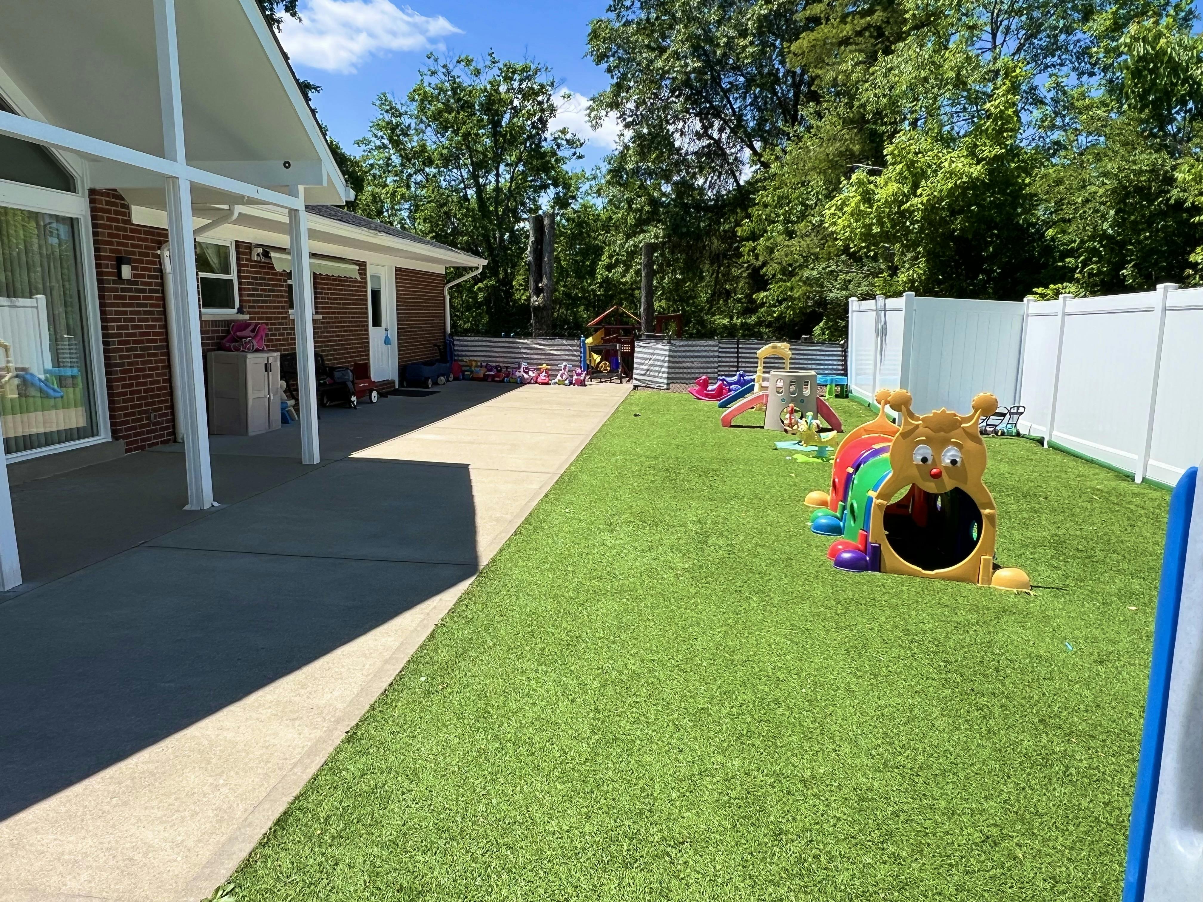 Outdoor play area with artificial turf and a caterpillar tunnel