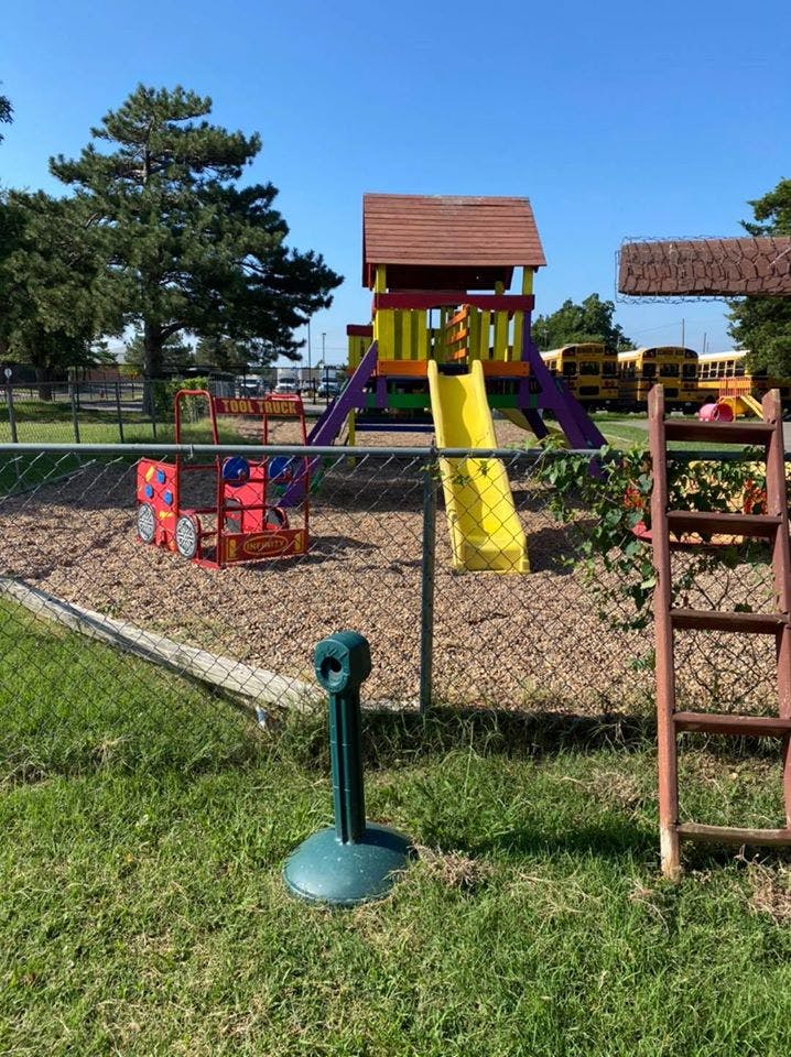 Playground with a slide, climbing structure, and a red toy car