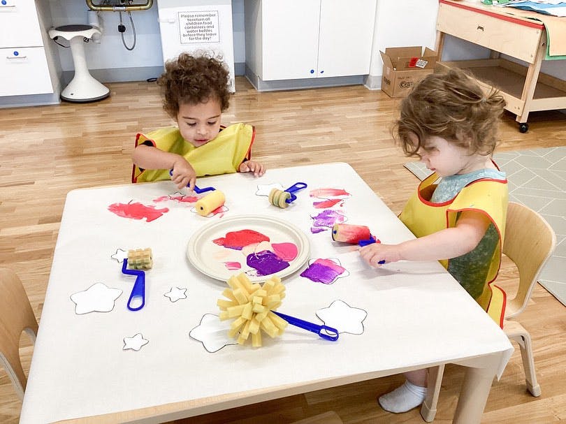 Two children painting at a table