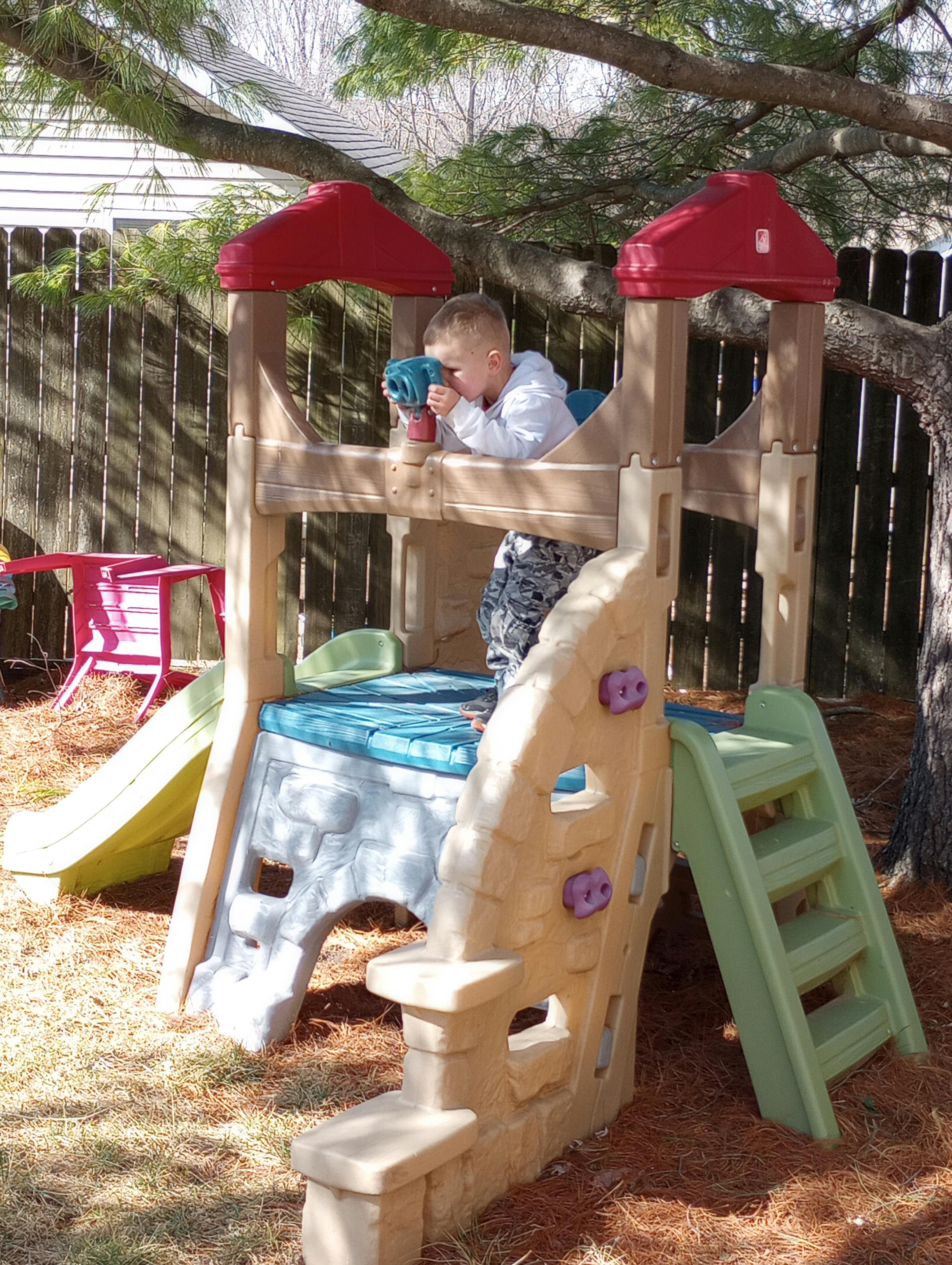 Child playing in a plastic outdoor playhouse