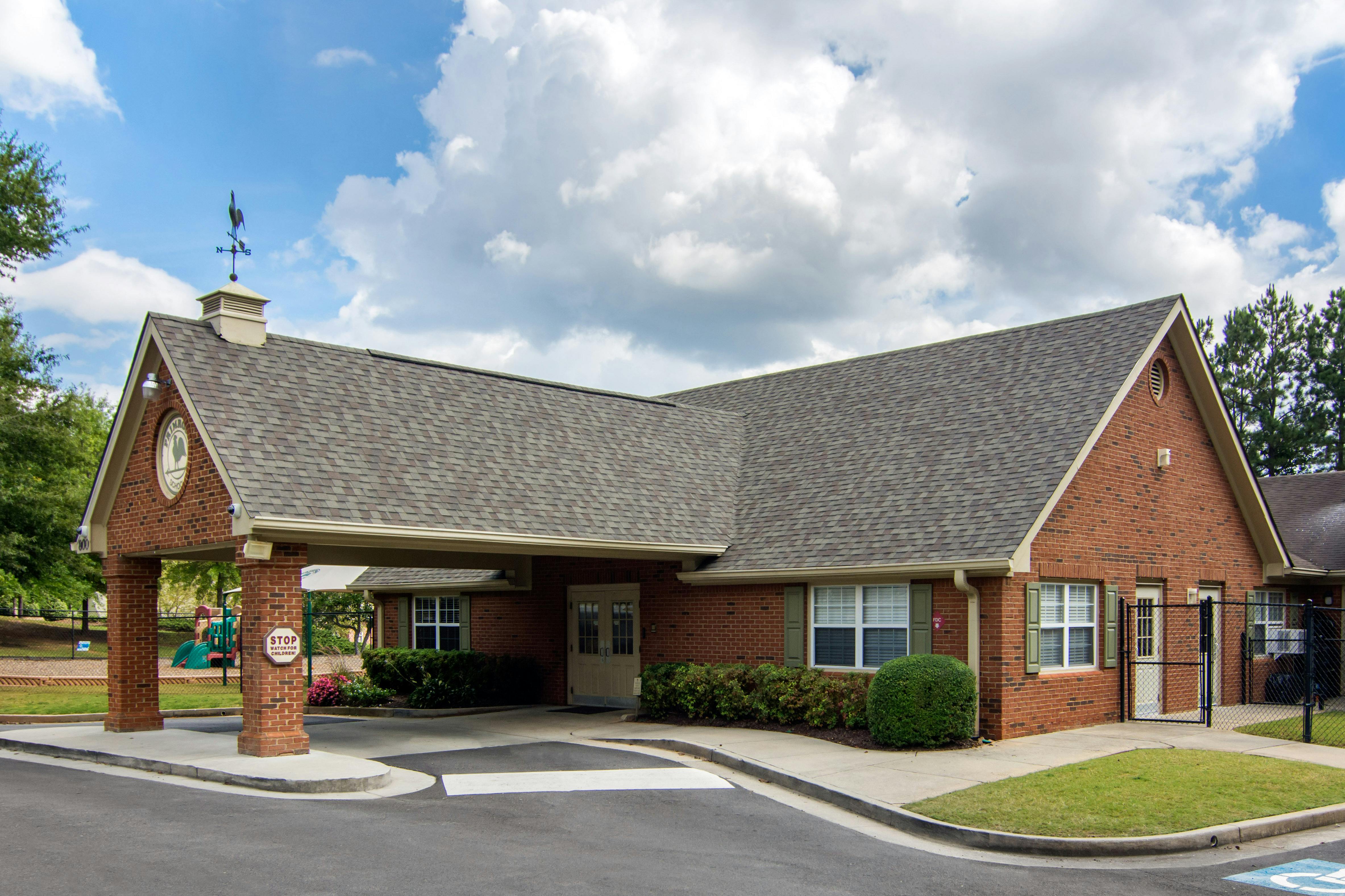 Brick building with a covered drive-through entrance and a weather vane on the roof