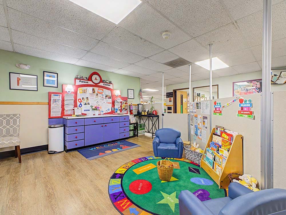 Children's room with a parent center, reading nook, and activity rug