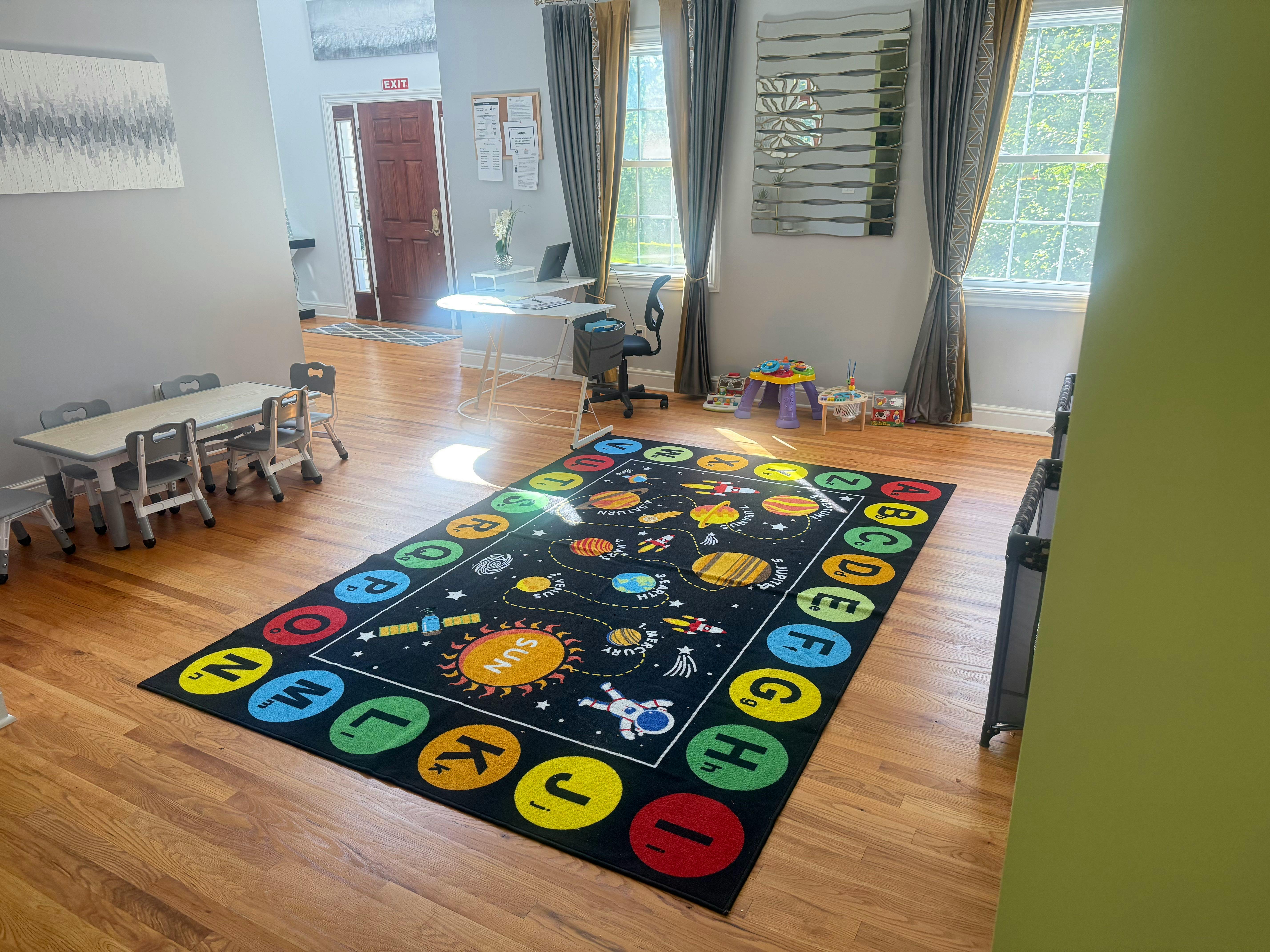 Playroom with a space-themed rug and small tables and chairs