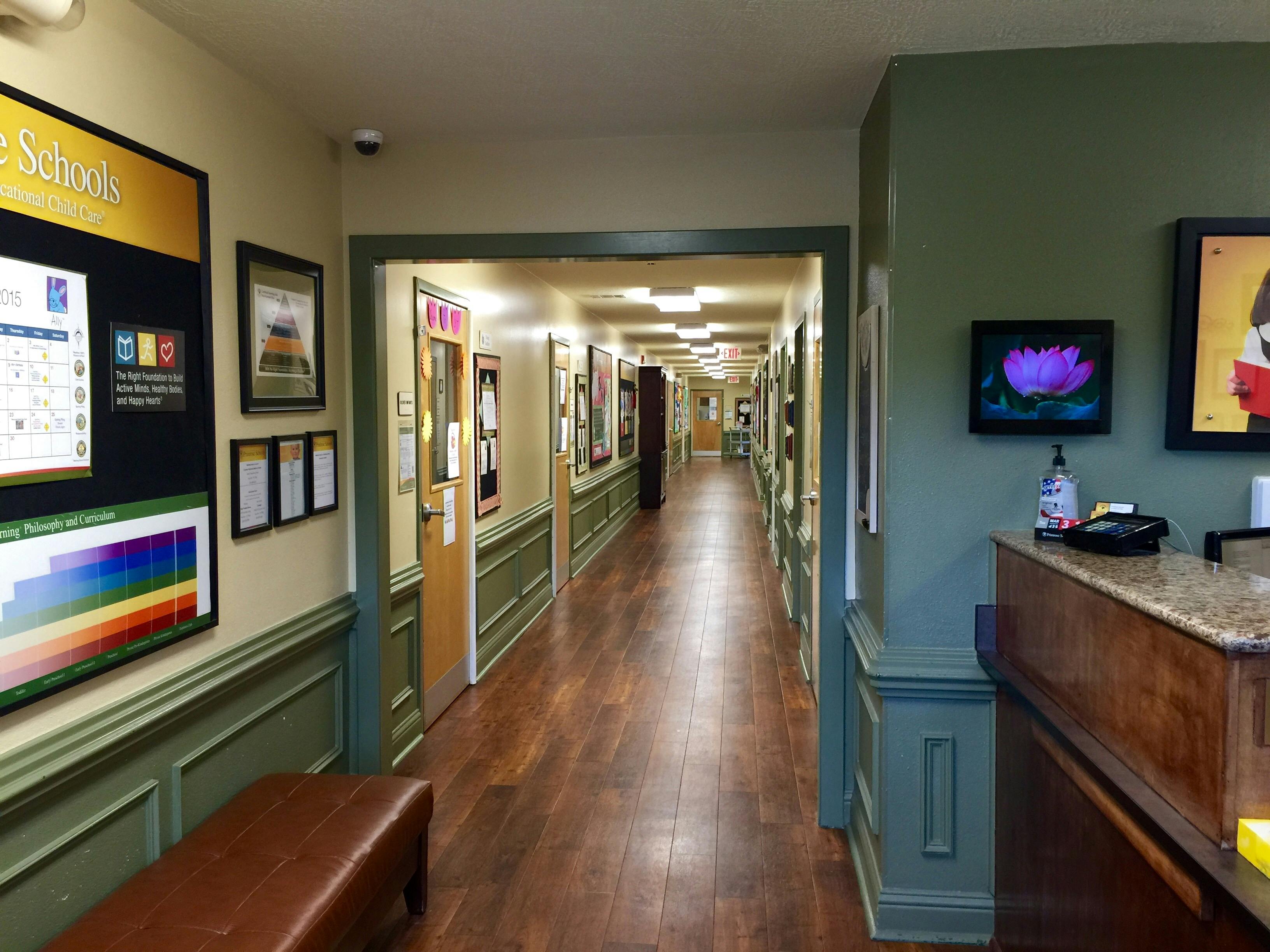Long hallway with wooden floor and green wainscoting