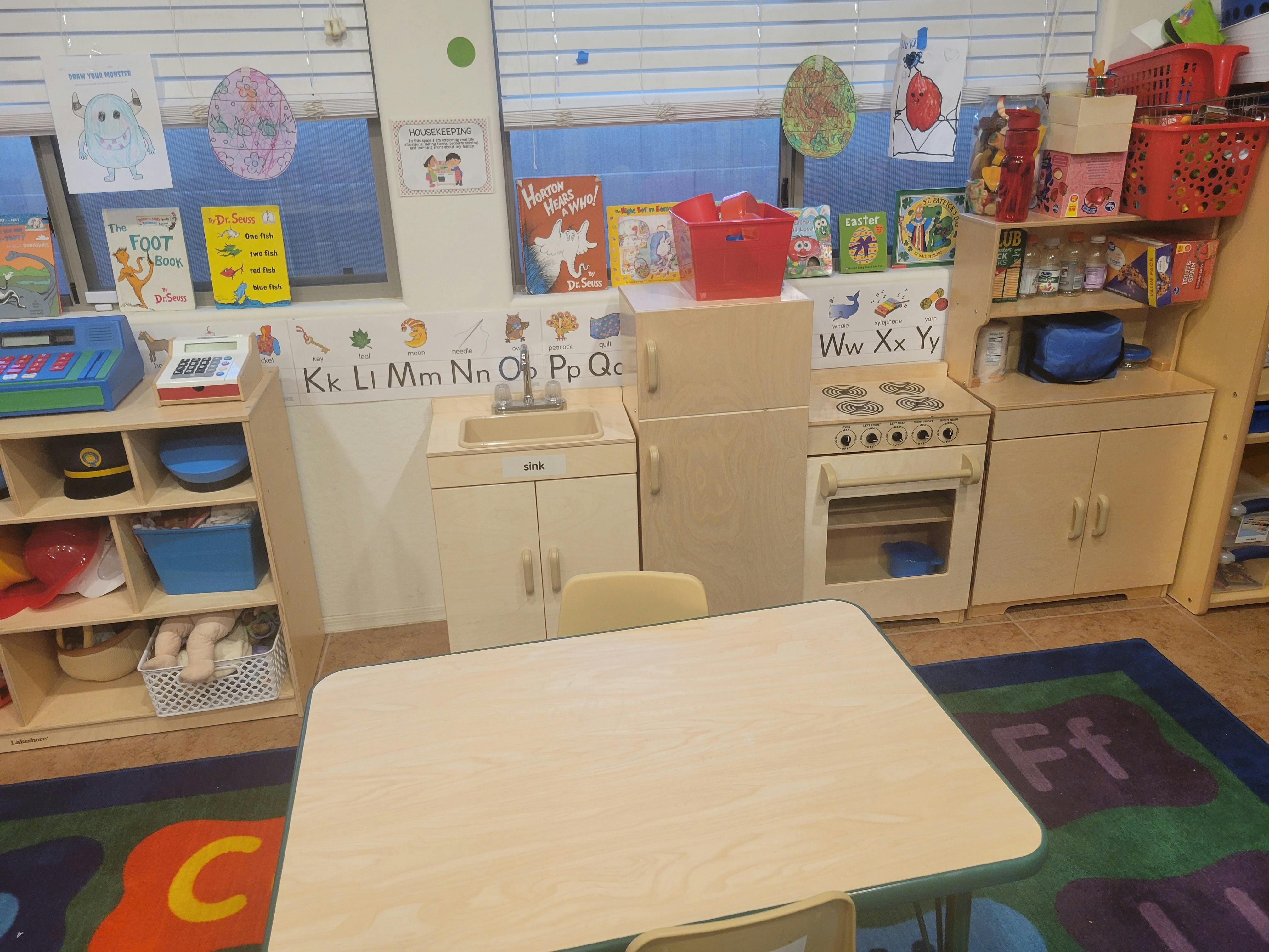 Play kitchen and shelves with toys in a classroom