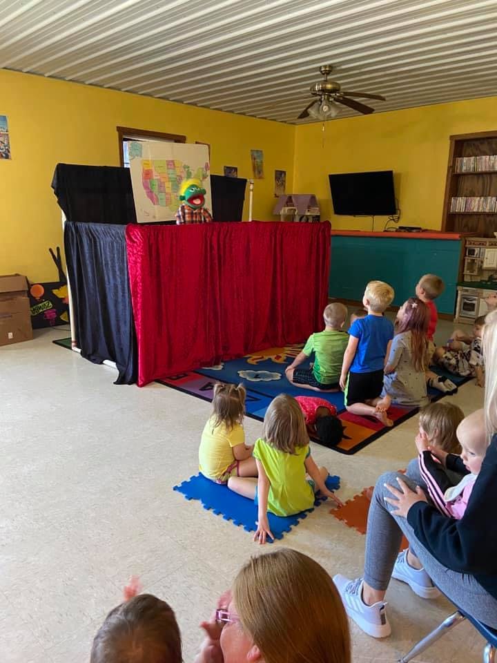 Children watching a puppet show in a classroom