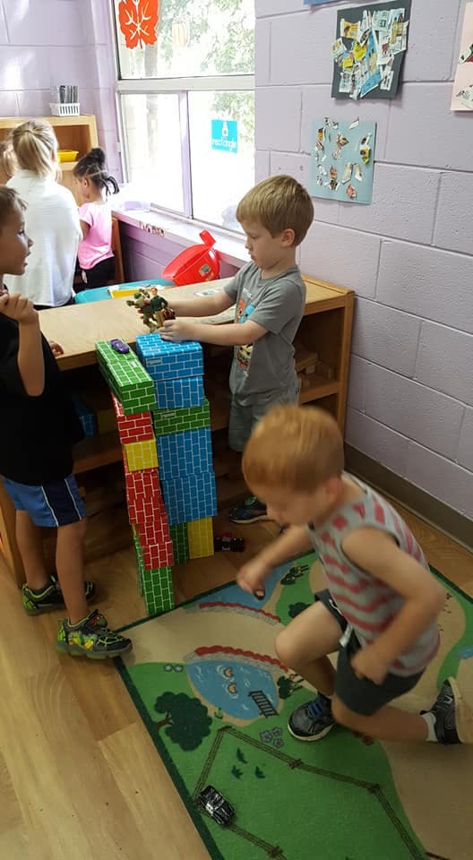 Children playing with blocks and toys in a classroom