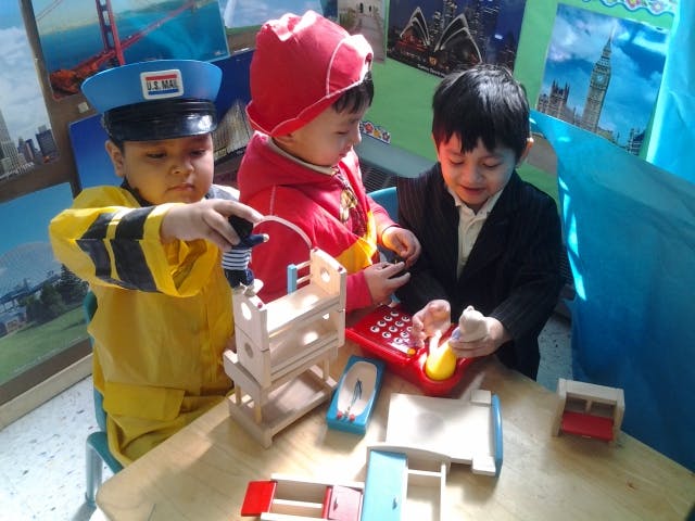 Three children playing with toys at a table