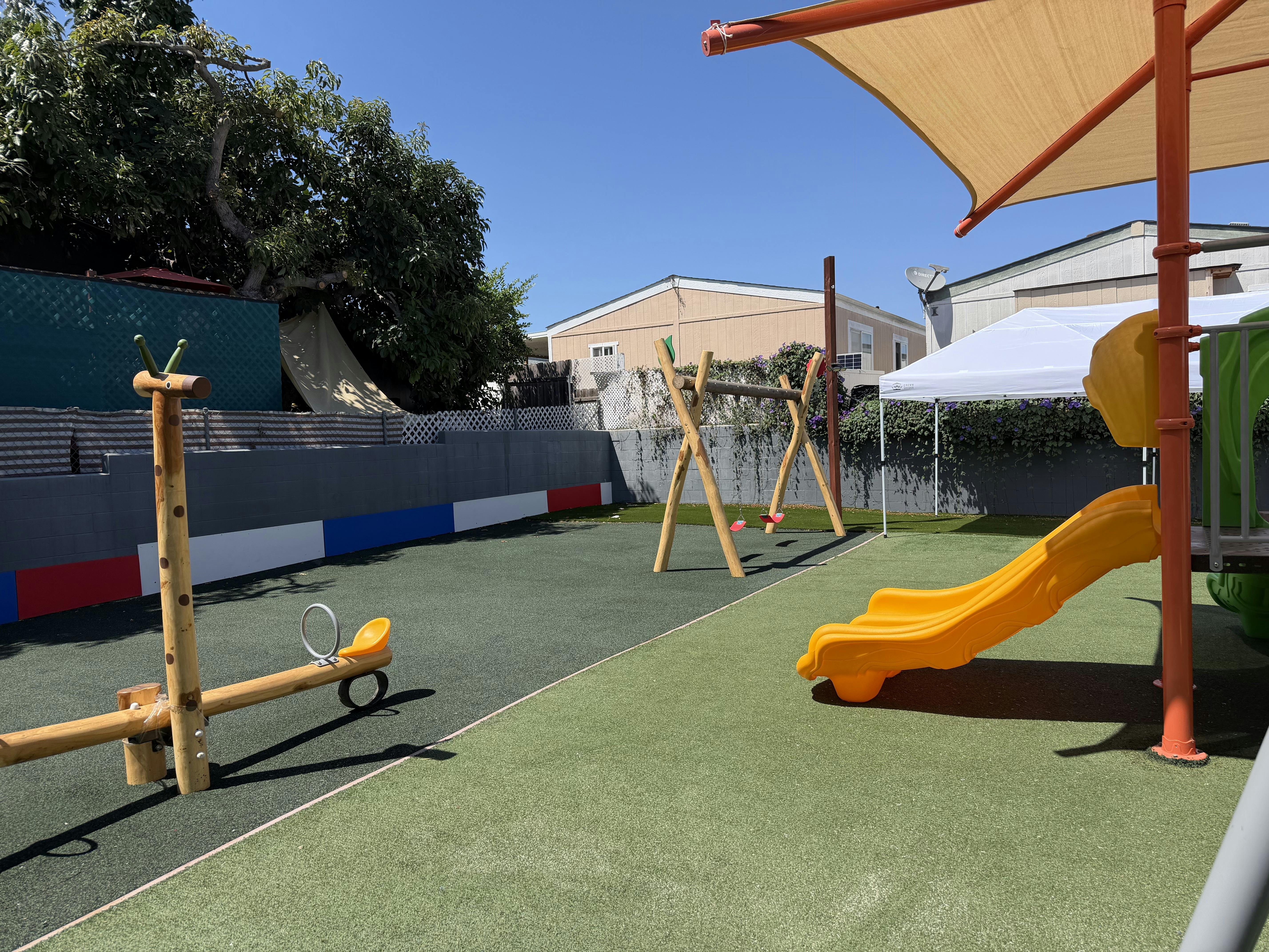 Childrens playground with a slide, swings, and a seesaw