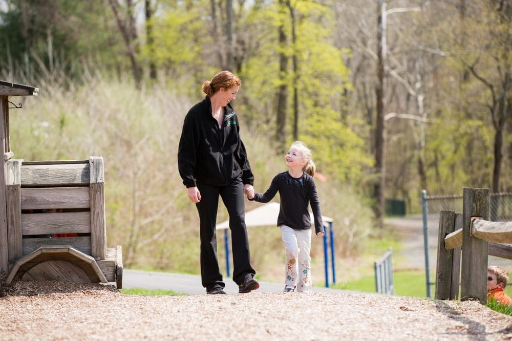 Person and child walking hand in hand outdoors
