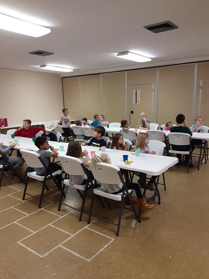 Children sitting at tables in a room