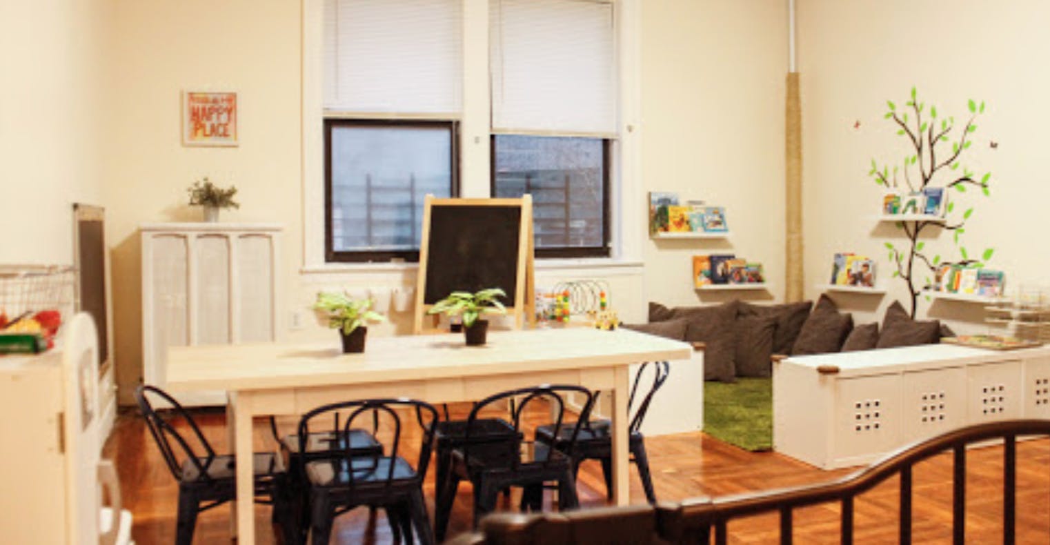 Classroom with a long table and chairs, chalkboard, and seating area