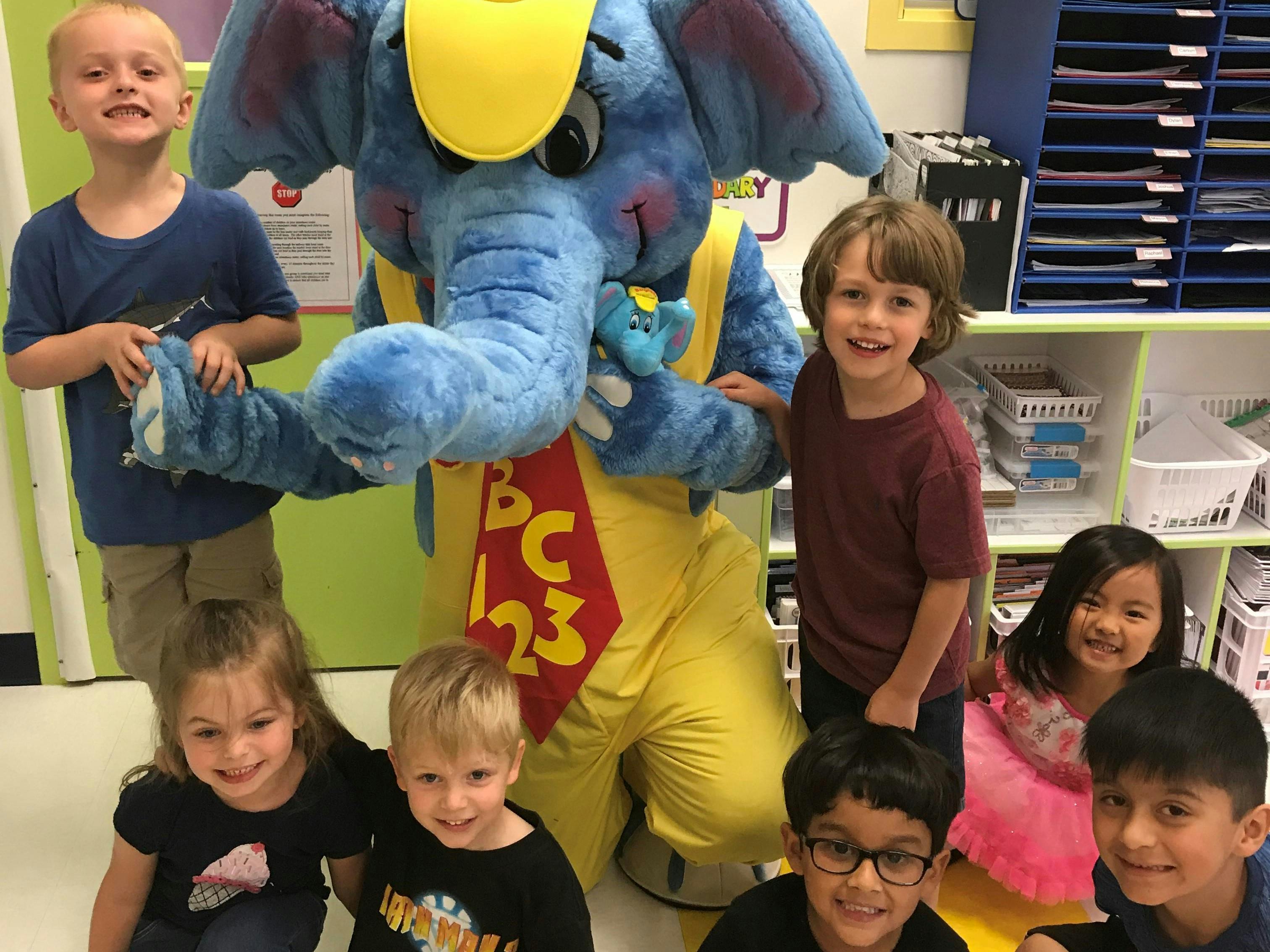 Children posing with a person in an elephant costume