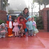 Adult and multiple children in costumes standing outdoors