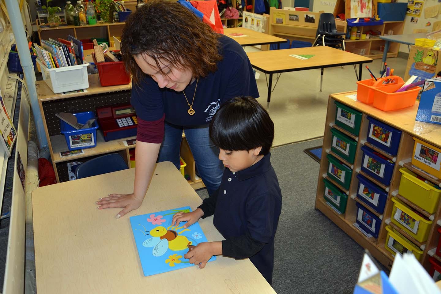 Adult and child working on a craft project in a classroom