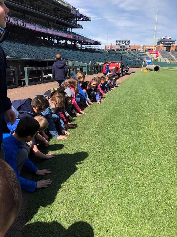 Children kneeling on a baseball field