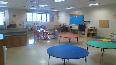 Empty classroom with colorful tables and chairs