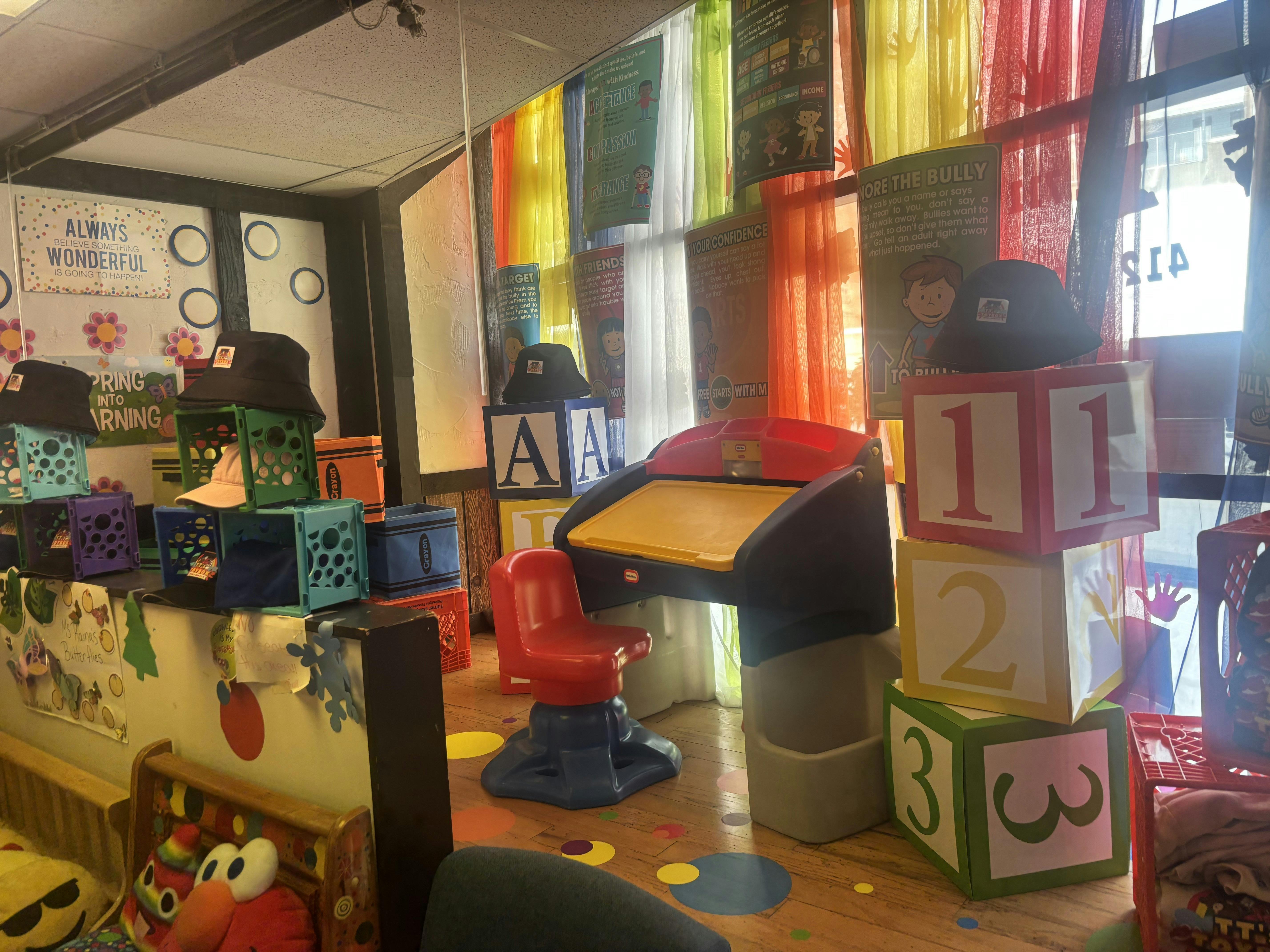Child's playroom with desk, red chair, colorful curtains, and oversized blocks with numbers and letters