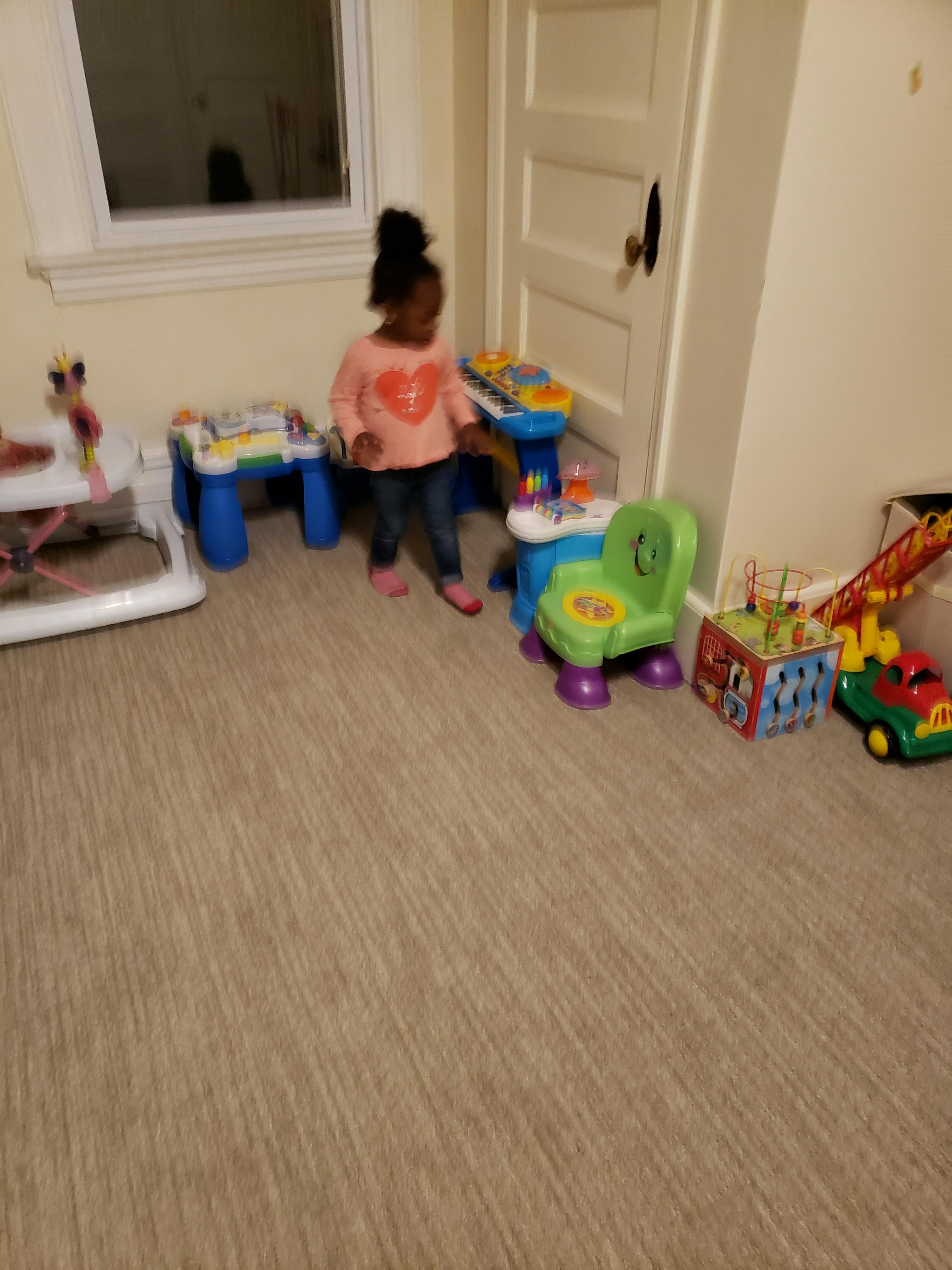 Child standing in a room with toys
