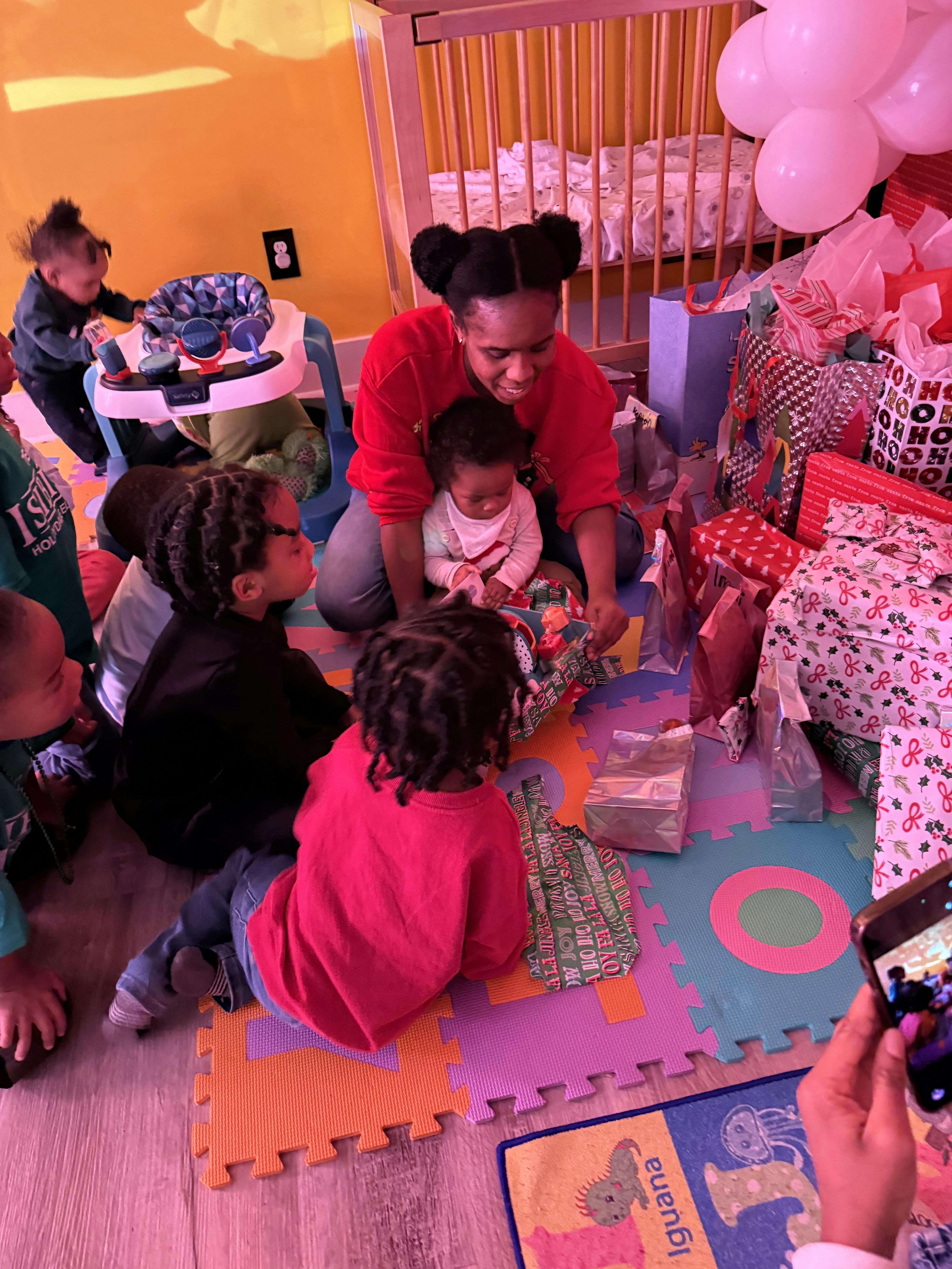 A group of people sitting on a floor with presents