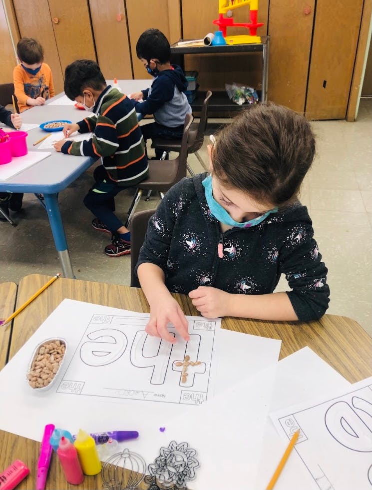 Child working on a craft project in a classroom