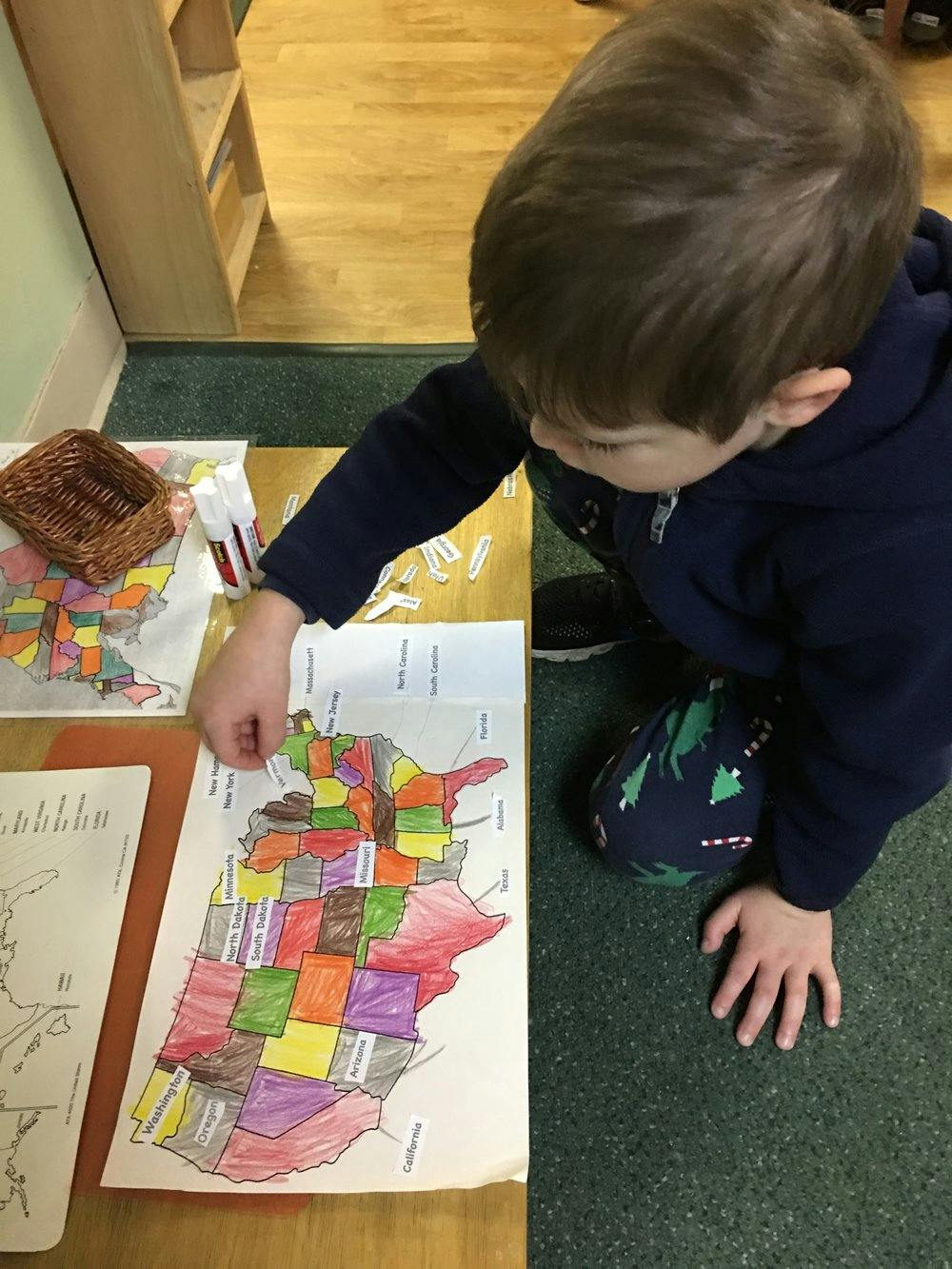 Child placing a piece on a colorful map of the United States