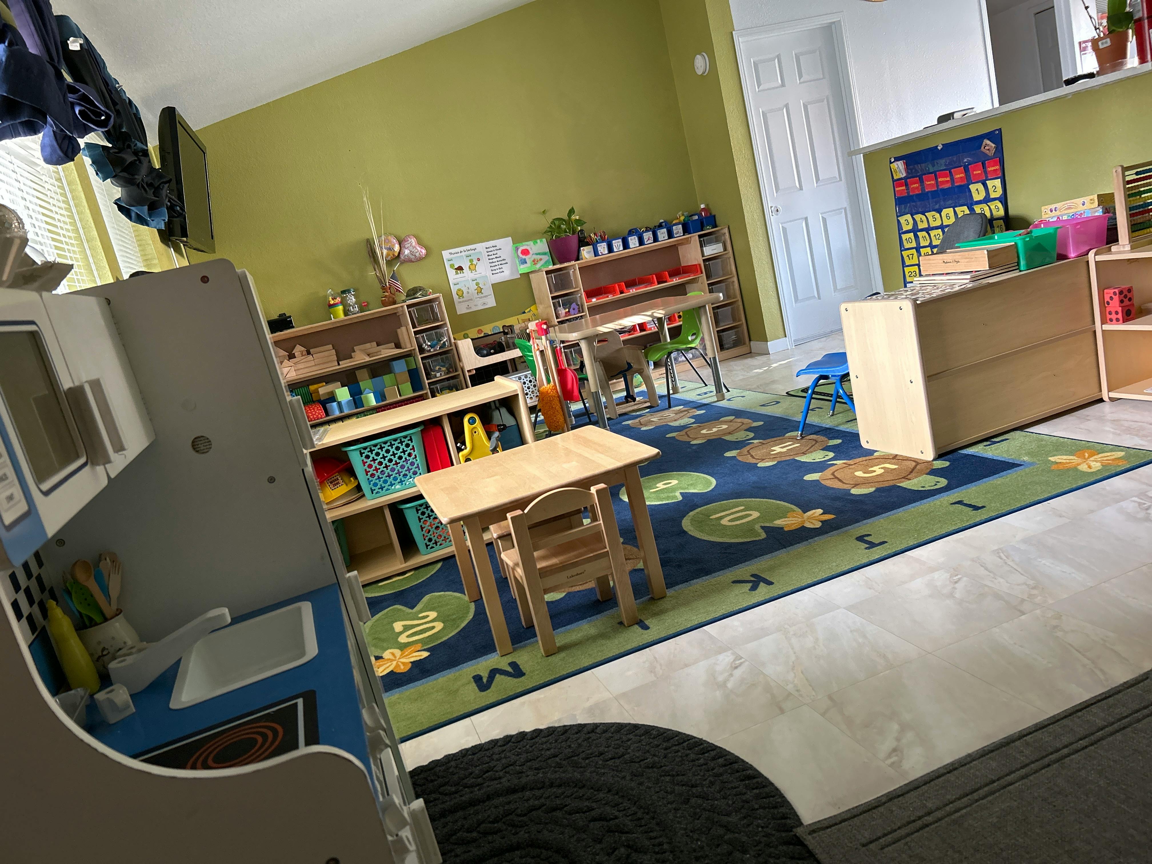 Child's play kitchen and small table with chairs in a classroom