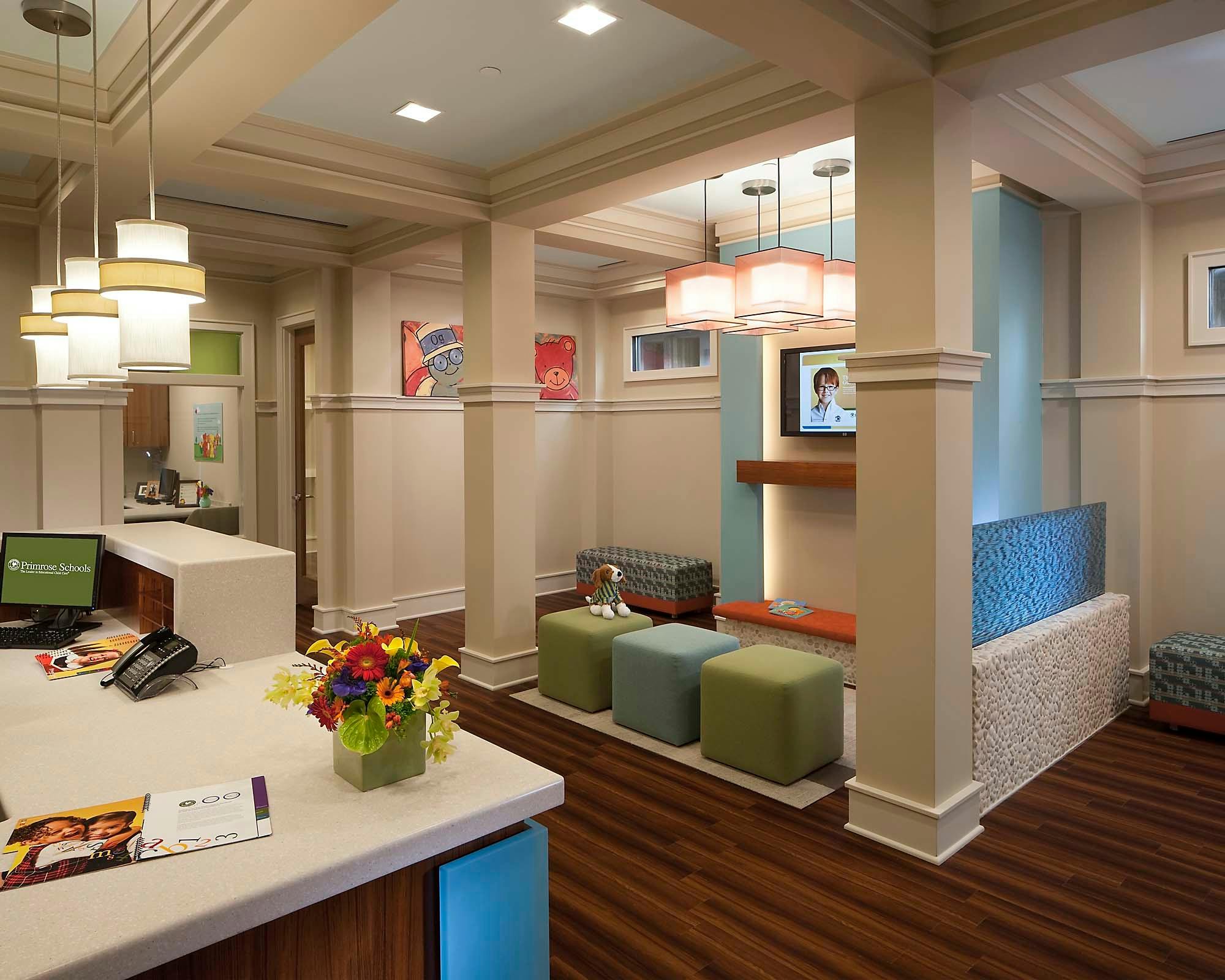 Reception area with a desk, flowers, and a waiting area with cube seats